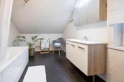 a bathroom with a sink and a bath tub at INN JOY Apartments - Sankt Gallen West in St. Gallen