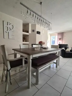 a dining table and chairs in a living room at HOME AWAY FROM HOME in Staad