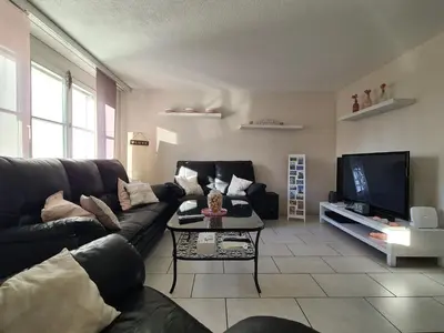 a living room with a black couch and a tv at HOME AWAY FROM HOME in Staad
