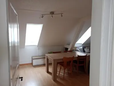 a dining room with a table and some chairs at Gemütliche Dachwohnung in St. Gallen