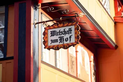 a sign hanging on the side of a building at Gasthaus Hof in Appenzell