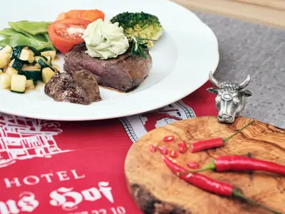 a plate of food with meat and vegetables on a table at Gasthaus Hof in Appenzell