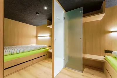 a small room with a bed and a glass wall at Gasthaus Hof in Appenzell