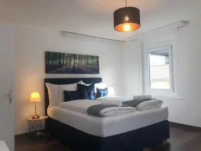 a large bed in a room with a window at INN JOY Apartments - Sankt Gallen Lachen in St. Gallen