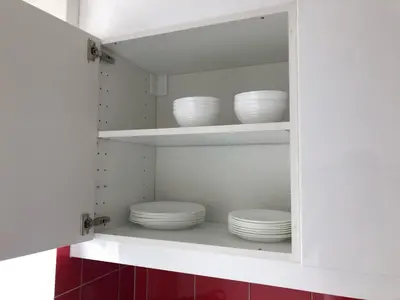 a kitchen with white plates and bowls on shelves at INN JOY Apartments - Sankt Gallen Lachen in St. Gallen