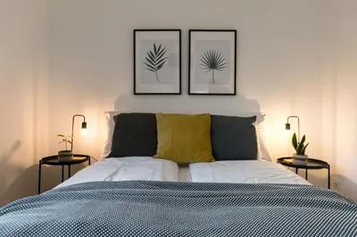 a bedroom with a bed with three pictures on the wall at INN JOY Apartments - Rorschach mit Panoramasicht in Rorschach