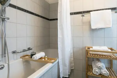 a bathroom with a tub and a sink and a shower at INN JOY Apartments - Rorschach mit Panoramasicht in Rorschach