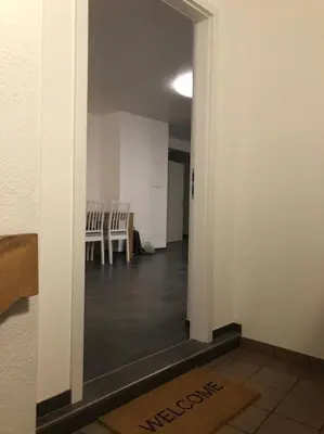 a hallway with a room with chairs and a table at INN JOY Apartments - Rorschach mit Panoramasicht in Rorschach