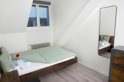a bedroom with a bed and a desk with a chair at RUSTICO INN - SIMPLE ROOMS -- OLMA Messen & Autobahn 1 Min, HSG 6 Min, Spital 7min, günstige Parkplätze in St. Gallen