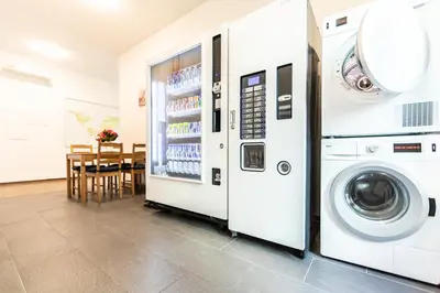 a washer and dryer in a kitchen next to a refrigerator at RUSTICO INN - SIMPLE ROOMS -- OLMA Messen & Autobahn 1 Min, HSG 6 Min, Spital 7min, günstige Parkplätze in St. Gallen