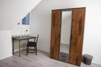 a mirror in a room with a table and a chair at RUSTICO INN - SIMPLE ROOMS -- OLMA Messen & Autobahn 1 Min, HSG 6 Min, Spital 7min, günstige Parkplätze in St. Gallen