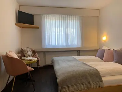 a bedroom with two beds with white sheets and pillows at Hotel B&B Stossplatz anytime and easy self Check-in in Appenzell