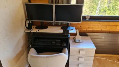 a desk with two computer monitors on top of it at Grosses Ferienhaus für traumhafte Familienferien im Appenzellerland in Speicher