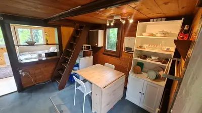 a small kitchen with a table and a desk in a tiny house at Grosses Ferienhaus für traumhafte Familienferien im Appenzellerland in Speicher