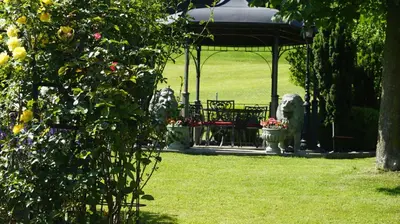 a park with a gazebo and a bench and flowers at Loft in der Natur mit Gartenzugang und Sauna in Herisau