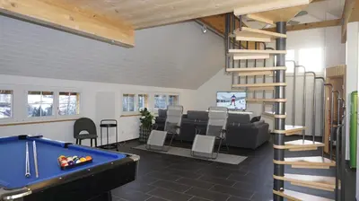 a living room with a pool table and a spiral staircase at Loft in der Natur mit Gartenzugang und Sauna in Herisau
