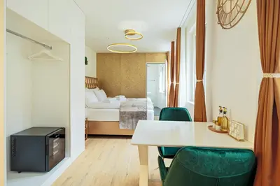 a room with a bed and a table and chairs at VISIMO Apartments Mühlensteg St Gallen - Elegant Quiet Central in St. Gallen