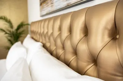 a gold bed with white sheets and pillows at VISIMO Apartments Mühlensteg St Gallen - Elegant Quiet Central in St. Gallen