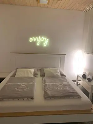 a bedroom with a bed with a neon sign on the wall at Guest room David 11 in St. Gallen