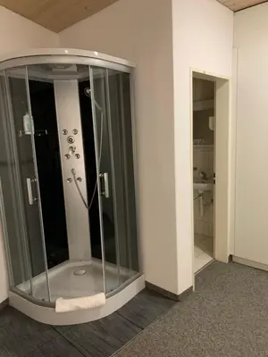 a glass shower in a room with a bathroom at Guest room David 11 in St. Gallen