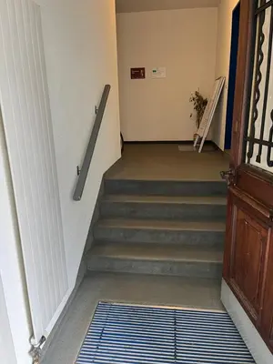 a hallway with a staircase with a door and a stair mat at Guest room David 11 in St. Gallen