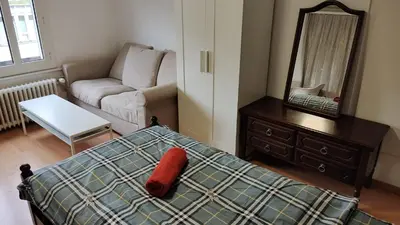 a bedroom with a bed and a mirror and a couch at City Home St Gallen in St. Gallen