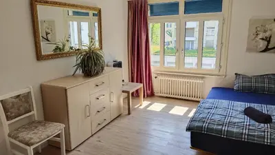 a bedroom with a bed and a dresser and a mirror at City Home St Gallen in St. Gallen