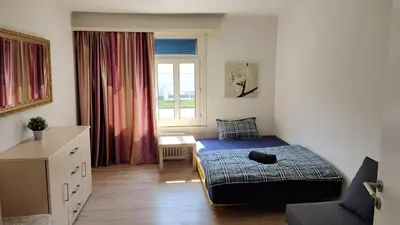 a small bedroom with a bed and a window at City Home St Gallen in St. Gallen
