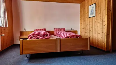 a bed with red and white pillows in a room at Gasthaus Rössli in Brülisau