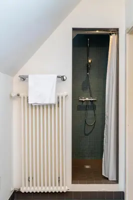 a bathroom with a radiator and a shower at Militärkantine St. Gallen in St. Gallen
