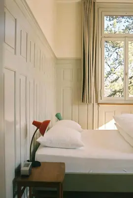 a bedroom with a white bed and a window at Militärkantine St. Gallen in St. Gallen