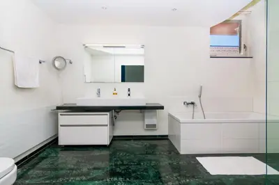 a bathroom with a sink and a tub and a toilet at Hotel Swiss Views in Hemberg
