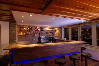 a bar with bar stools in a room at Hotel Swiss Views in Hemberg