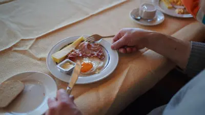 a person sitting at a table with a plate of breakfast food at Hotel Swiss Views in Hemberg