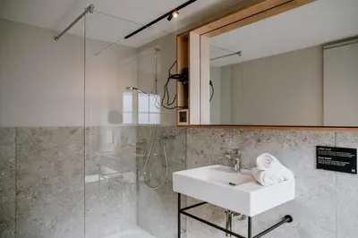 a bathroom with a sink and a shower at Hotel Müllers - Self-Check-in in Arbon