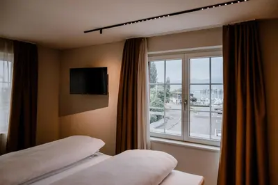 a hotel room with two beds and a window at Hotel Müllers - Self-Check-in in Arbon