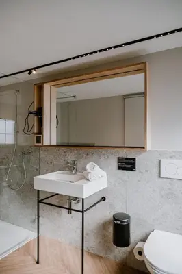 a bathroom with a sink and a mirror at Hotel Müllers - Self-Check-in in Arbon