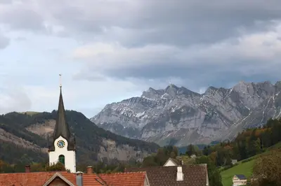 a green field with mountains in the background at Schlafen im Sternen Ennetbühl in Nesslau