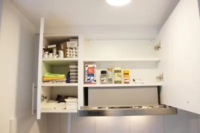 a kitchen with white cabinets and shelves at Casa Schilling 2,5 rooms in St Gallen, modern, quiet and close to the center in St. Gallen