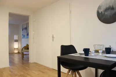 a dining room with a black table and chairs at Casa Schilling 2,5 rooms in St Gallen, modern, quiet and close to the center in St. Gallen