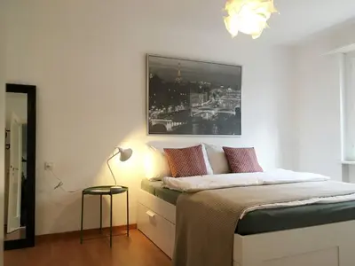 a bedroom with a bed with a picture on the wall at 2 rooms with balcony, central, quiet location in St. Gallen