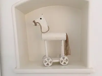 a wooden toy horse in a niche in a wall at 2 rooms with balcony, central, quiet location in St. Gallen