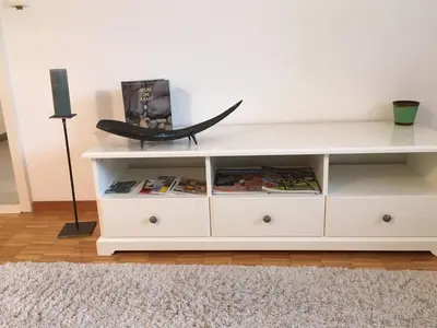 a white book shelf with a boat on it at 2 rooms with balcony, central, quiet location in St. Gallen