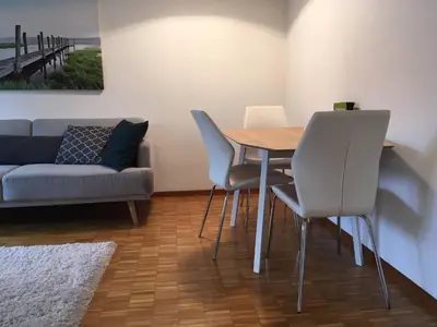 a living room with a table and chairs and a couch at 2 rooms with balcony, central, quiet location in St. Gallen