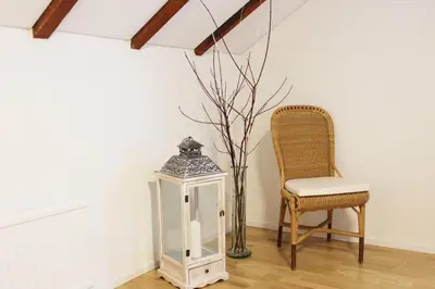 a white room with a chair and a lantern at Completely renovated apartment near the train station and the center in St. Gallen