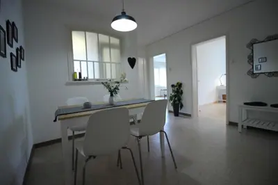 a dining room with a table and white chairs at Casa Schilling- 2,5 rooms with balcony near hospital, university in St. Gallen