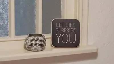 a window sill with two vases and a sign that says let life surprise you at Casa Schilling- 2,5 rooms with balcony near hospital, university in St. Gallen