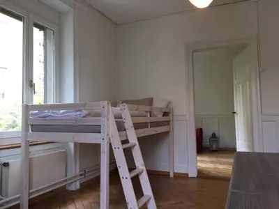 a room with a bunk bed and a ladder at Casa Schilling - 4 charming rooms in the best location in St. Gallen