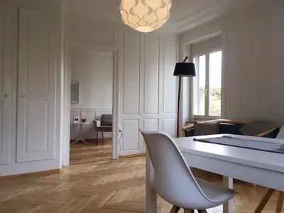 a living room with a table and chairs and a room with a couch at Casa Schilling - 4 charming rooms in the best location in St. Gallen