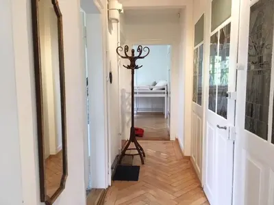 a hallway with a floor lamp and a mirror at Casa Schilling - 4 charming rooms in the best location in St. Gallen